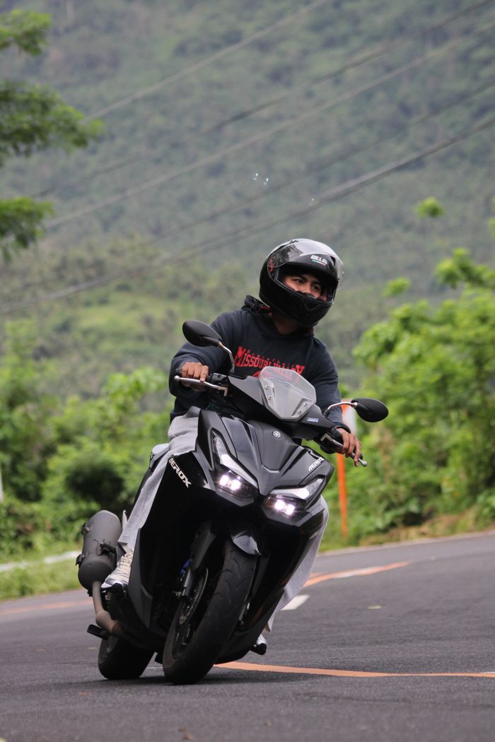 A motorcyclist rides through the scenic green landscapes of Sagnay, Bicol, Philippines.